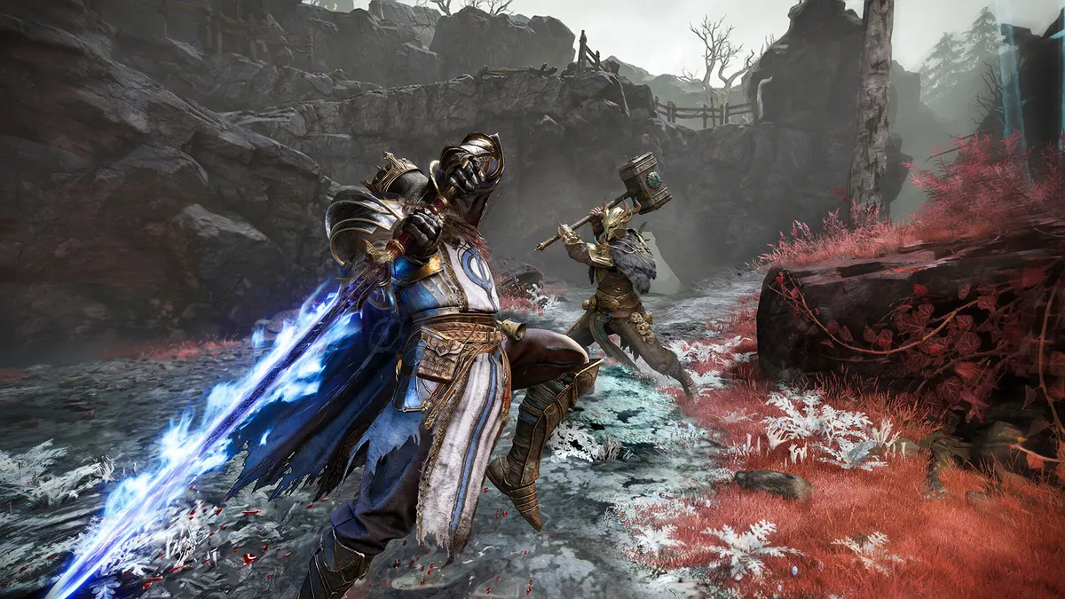 Two armored hunters advancing across a rocky slope covered in red flowers